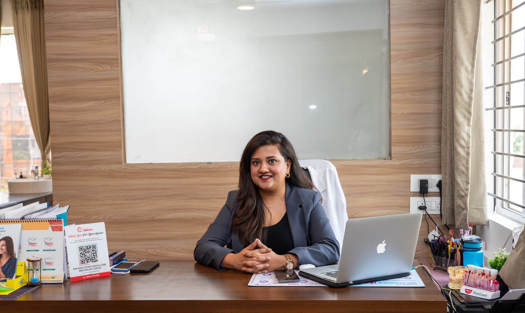 Dr. Sushma D'Souza at her desk at The Smile Studio